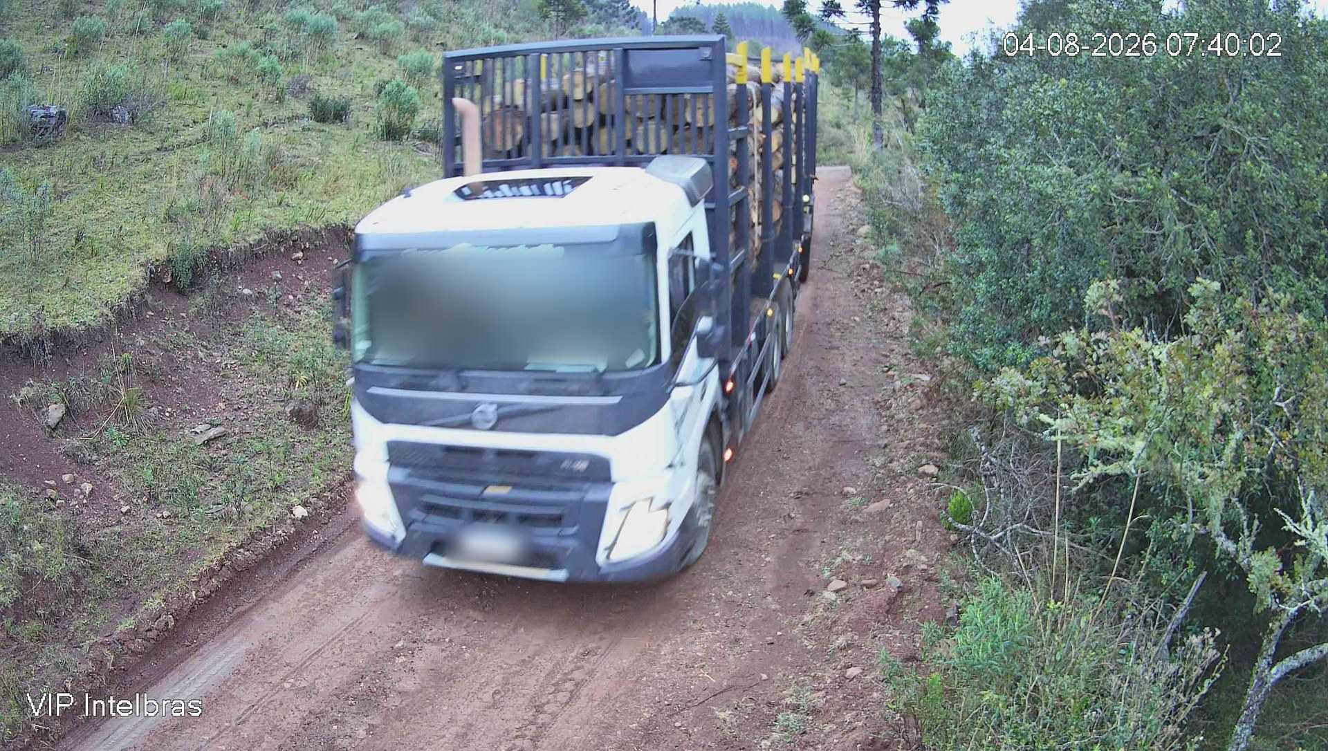 Caminhão carregado de toras em estrada de terra, visto pela câmera, com a moldura de detecção “Caminhão” desenhada pela IA