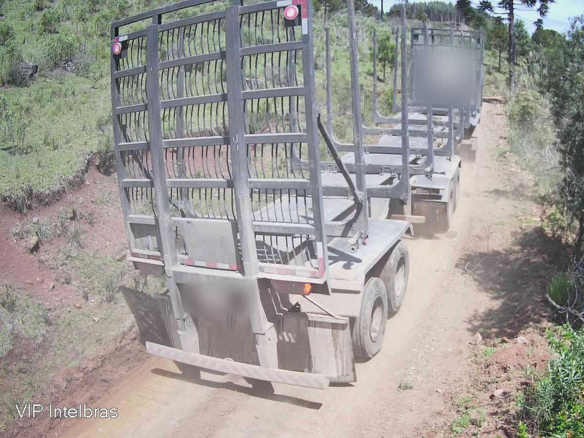 Caminhão com reboque florestal vazio em estrada de terra, com a moldura “Caminhão” marcada pela IA
